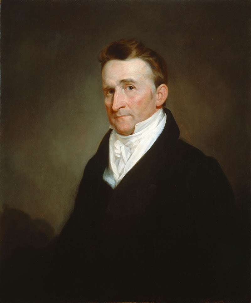 Portrait of a man in formal attire with a white shirt and dark jacket against a brown background