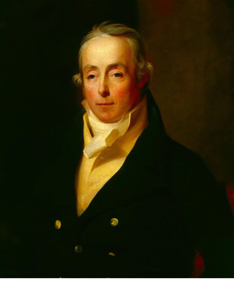 Portrait of a man in formal attire with a dark background