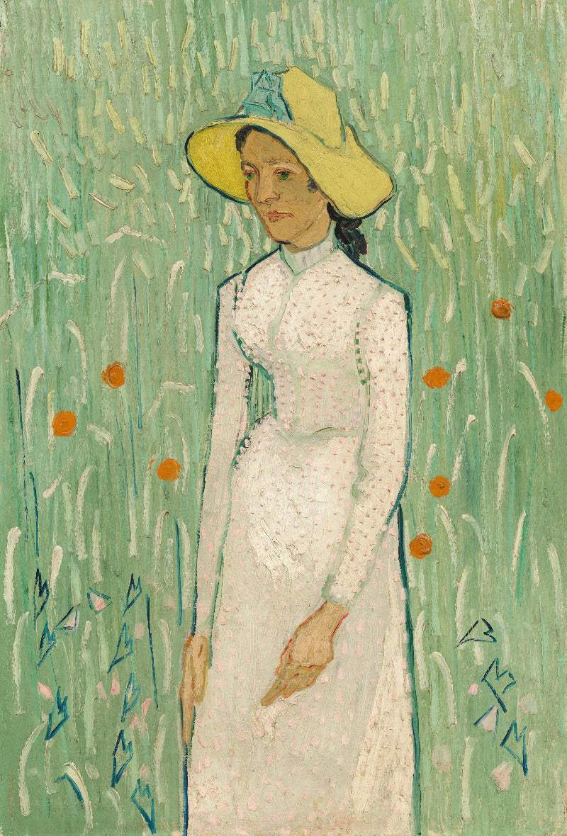 Woman in a white dress and yellow hat standing in a field with flowers