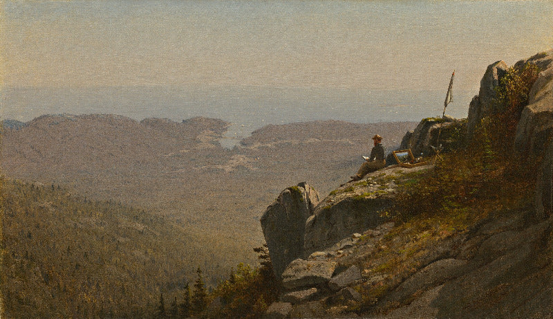 Person sitting on a rocky outcrop overlooking a vast landscape with mountains and trees.