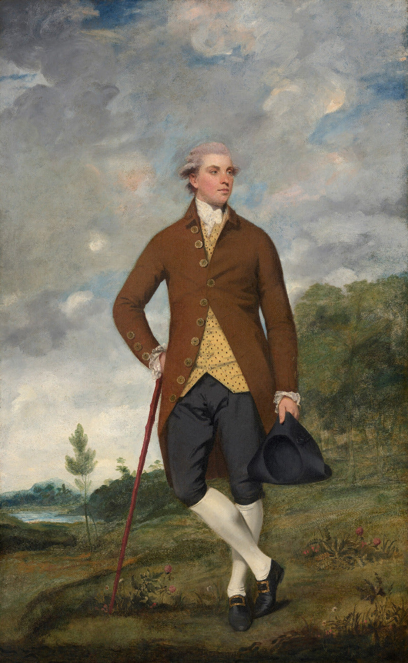 Portrait of a man in formal attire standing outdoors with a landscape background
